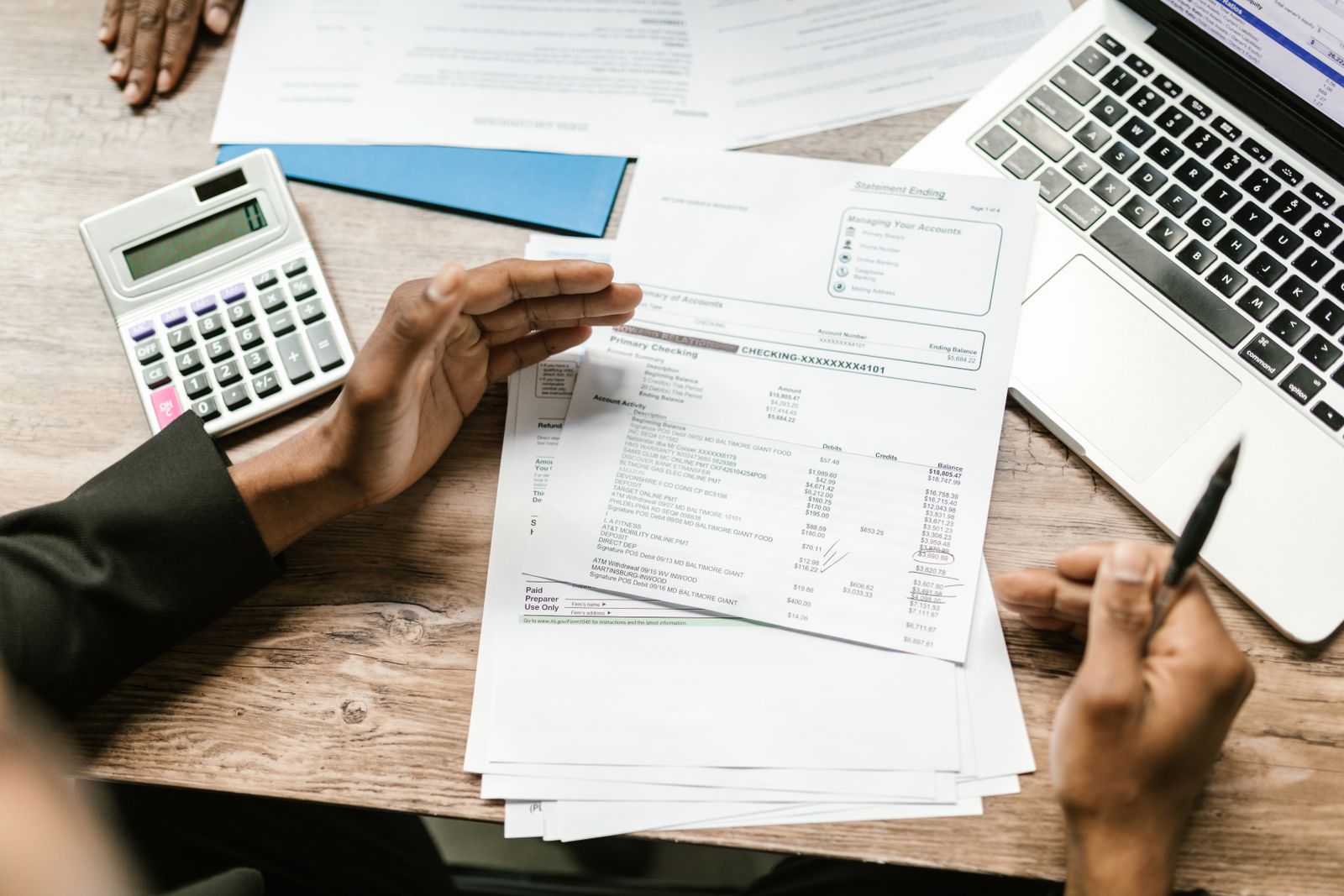 Accountant reviewing financial documents at a desk with a calculator and laptop
